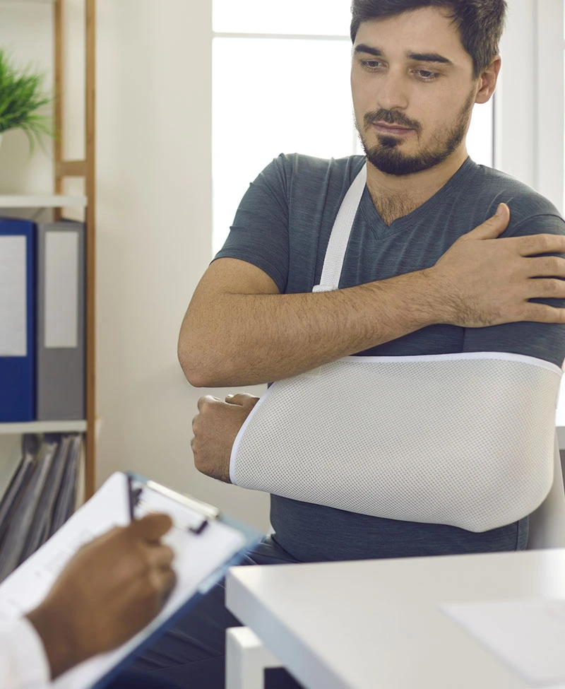 un employé avec un bras cassé profite de la protection sociale lors d'une consultation